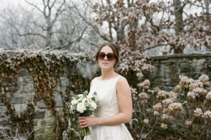 Mariée en décembre portant des lunettes de soleil tendance écaille de tortue dans un jardin hivernal givré