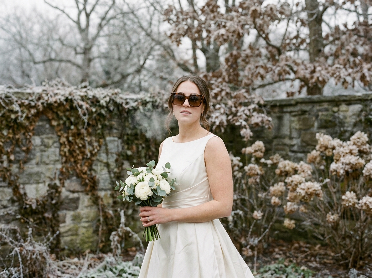 Mariée en décembre portant des lunettes de soleil tendance écaille de tortue dans un jardin hivernal givré